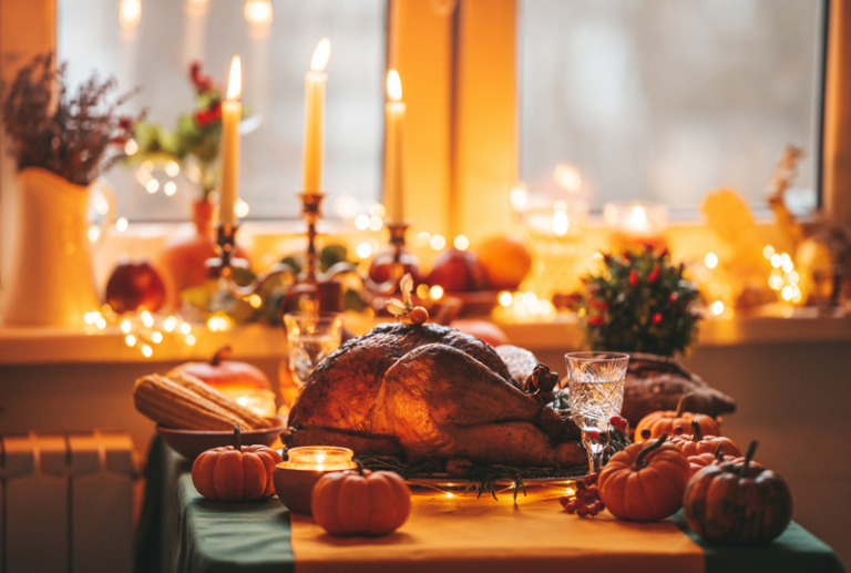 Image is of a dinner table with a Thanksgiving feast and candles, concept of making Thanksgiving brighter with Family Windows & Doors